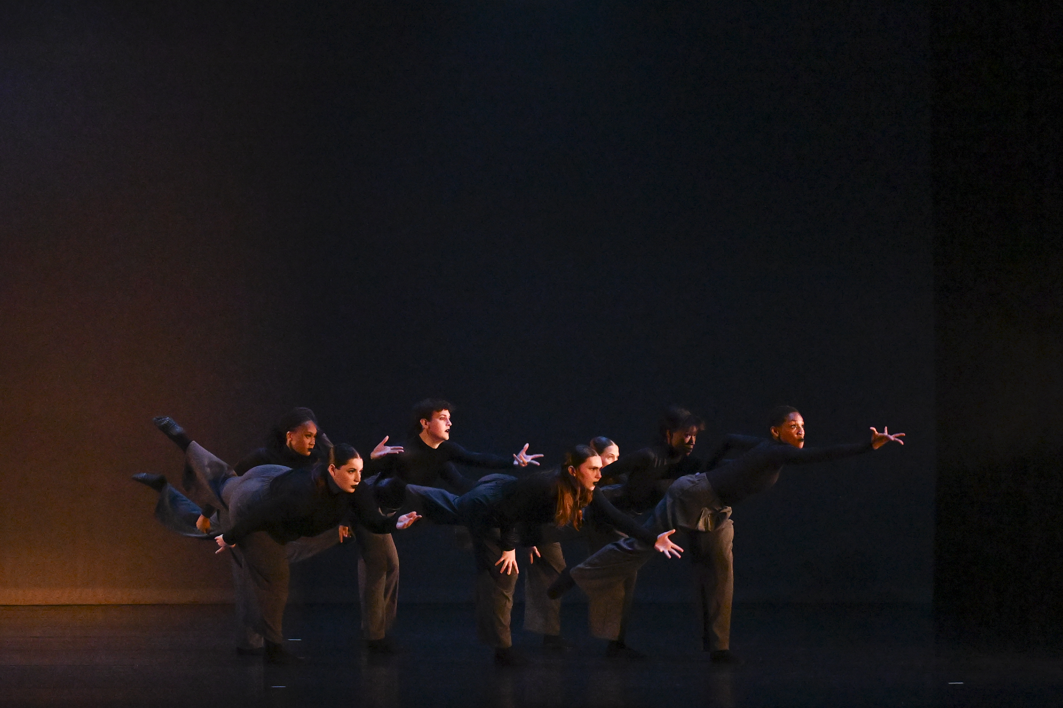 Performance Foundation Several dancers in a line lean and point toward the right of the frame